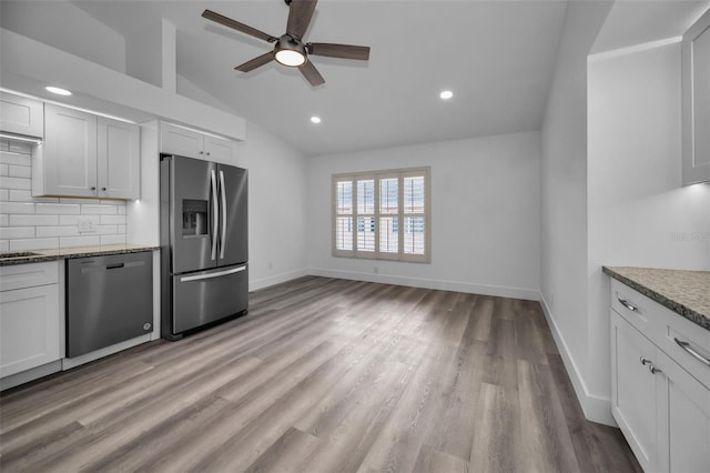 kitchen featuring appliances with stainless steel finishes, vaulted ceiling, white cabinetry, and ceiling fan