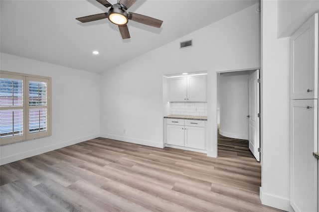 unfurnished living room featuring light hardwood / wood-style flooring, ceiling fan, and lofted ceiling