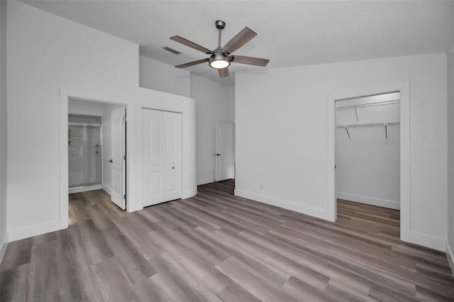 unfurnished bedroom with connected bathroom, ceiling fan, a textured ceiling, and light wood-type flooring