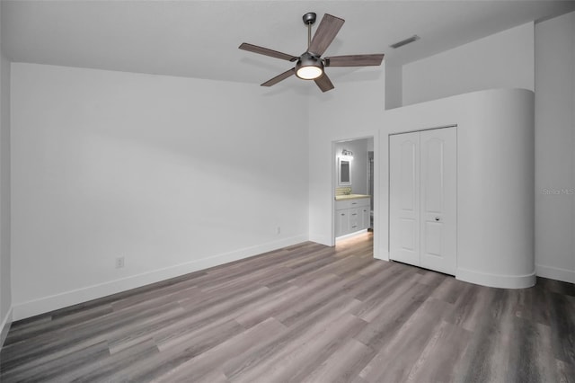 unfurnished bedroom featuring a closet, hardwood / wood-style flooring, and ceiling fan