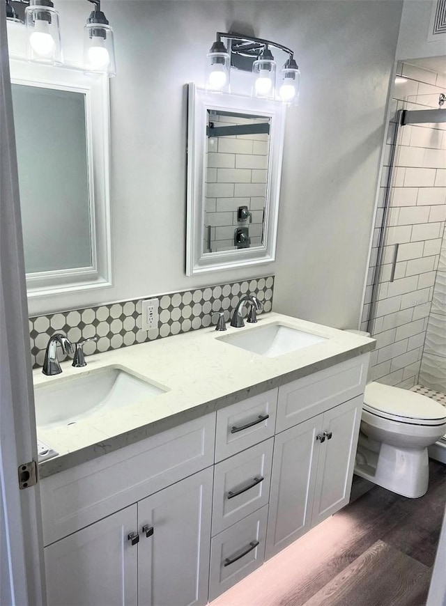 bathroom with vanity, hardwood / wood-style floors, backsplash, and toilet