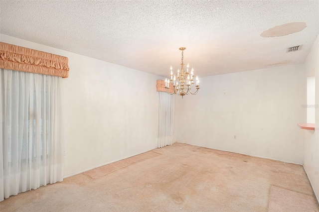 unfurnished room featuring carpet flooring, a textured ceiling, and a notable chandelier