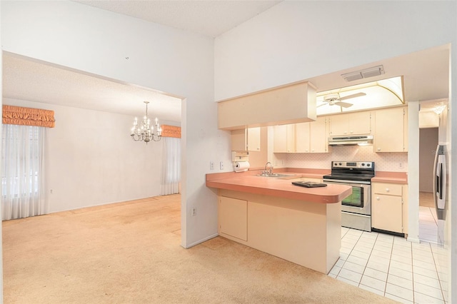 kitchen featuring kitchen peninsula, cream cabinets, light colored carpet, stainless steel range with electric stovetop, and ceiling fan with notable chandelier