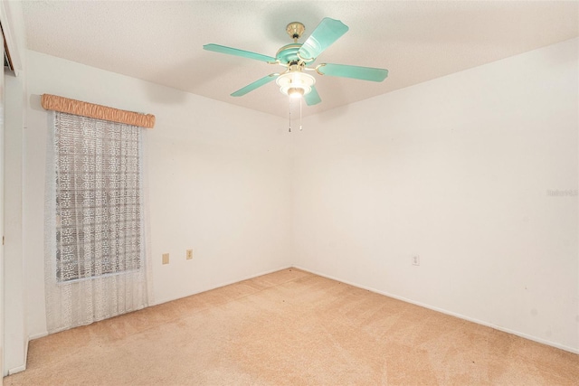 empty room featuring ceiling fan and light carpet