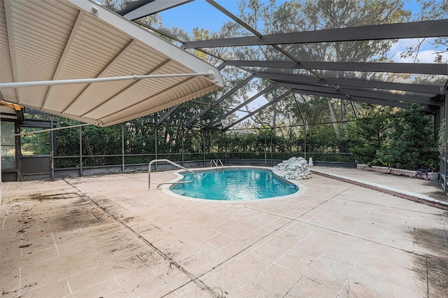 view of pool with glass enclosure and a patio area