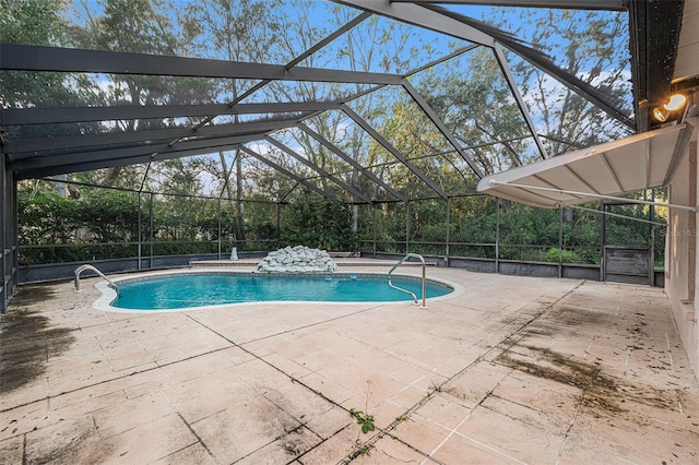 view of pool with glass enclosure and a patio area