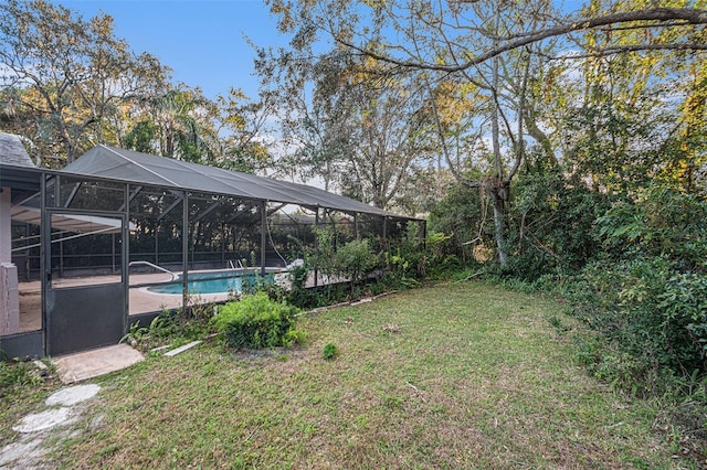 view of yard featuring glass enclosure and a patio