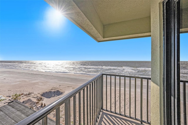 balcony featuring a water view and a beach view