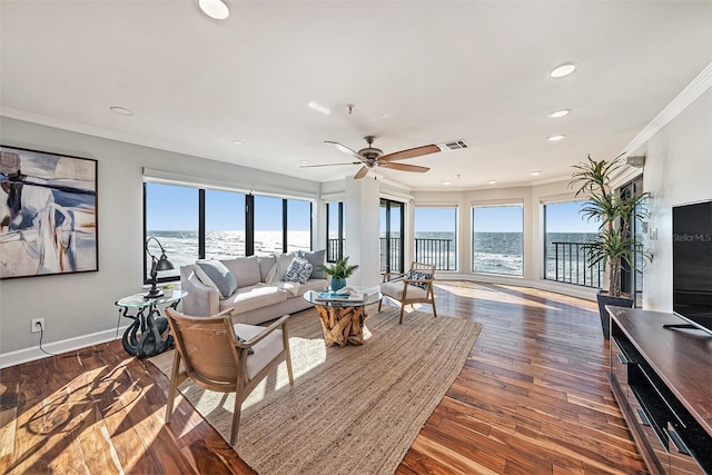 living room featuring dark hardwood / wood-style floors, ceiling fan, a water view, and ornamental molding