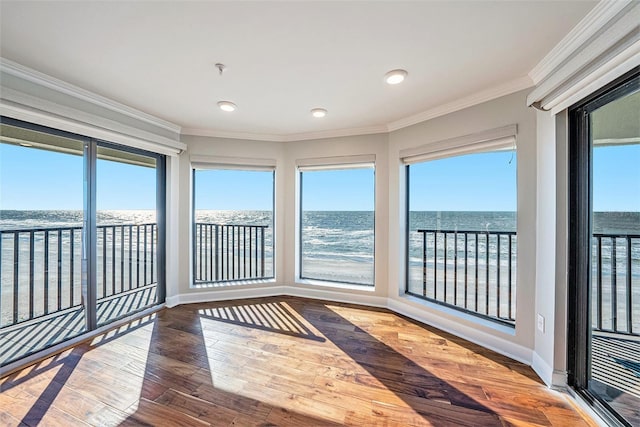 unfurnished sunroom with a water view and a view of the beach