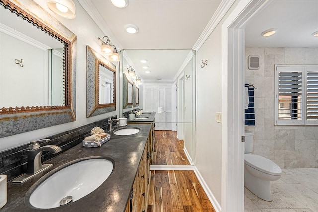 bathroom featuring hardwood / wood-style floors, vanity, toilet, and crown molding