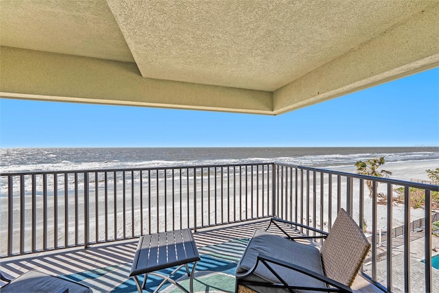 balcony with a beach view and a water view