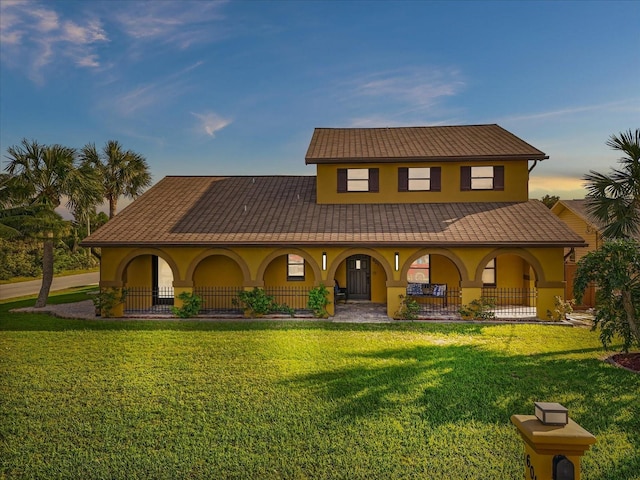 mediterranean / spanish house featuring a yard