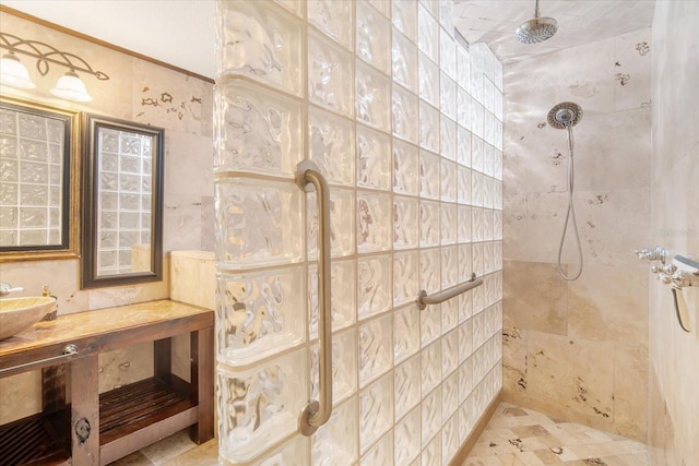 bathroom with a tile shower and sink