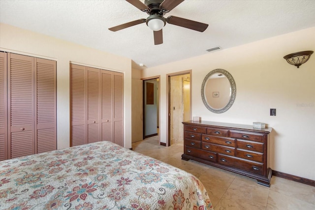 tiled bedroom with multiple closets, ceiling fan, and a textured ceiling