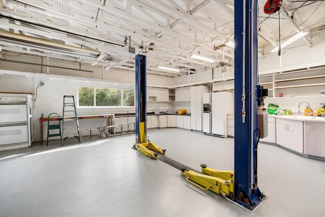 garage featuring white fridge with ice dispenser and sink