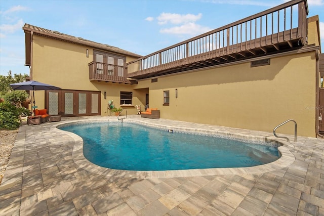 view of swimming pool featuring a patio area and french doors