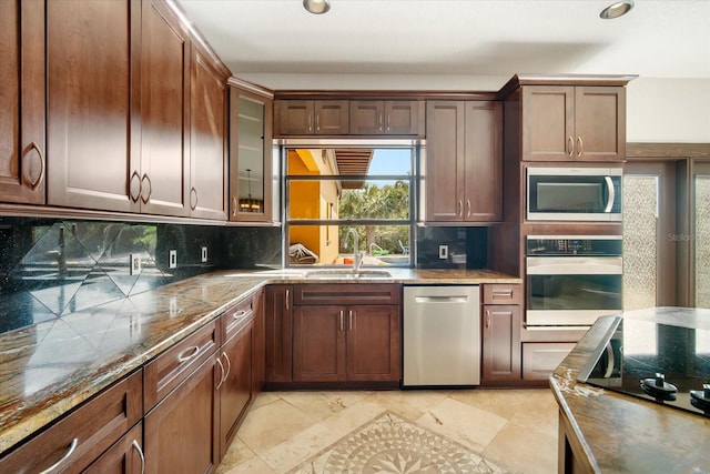 kitchen featuring dark stone countertops, sink, backsplash, and stainless steel appliances