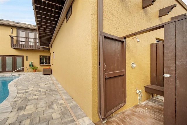 view of side of home featuring a patio and french doors