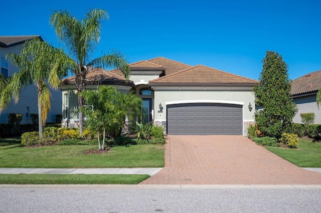 mediterranean / spanish home with a garage and a front lawn