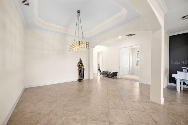 empty room featuring a tray ceiling and ornamental molding