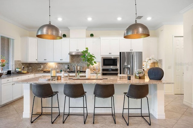 kitchen featuring light stone countertops, appliances with stainless steel finishes, a kitchen island with sink, and hanging light fixtures