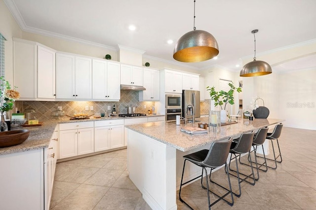 kitchen with stainless steel appliances, white cabinetry, hanging light fixtures, and a kitchen island with sink