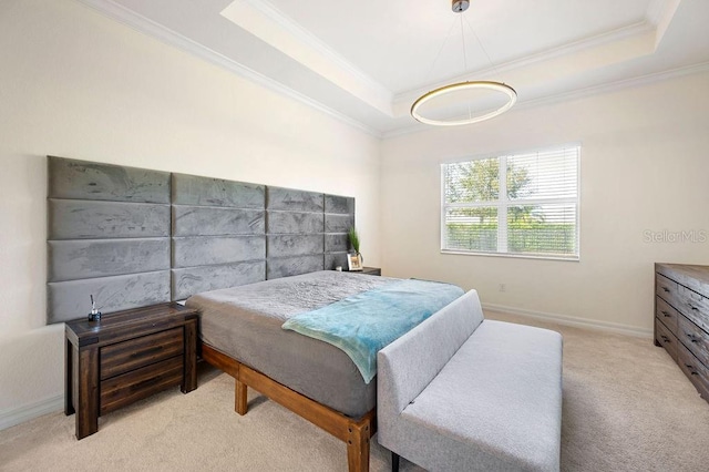 carpeted bedroom with ornamental molding and a tray ceiling