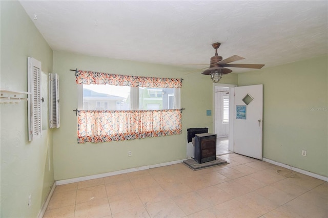 entryway with ceiling fan and a wood stove