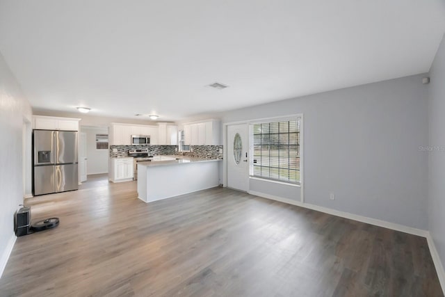 kitchen with white cabinets, appliances with stainless steel finishes, light wood-type flooring, and kitchen peninsula