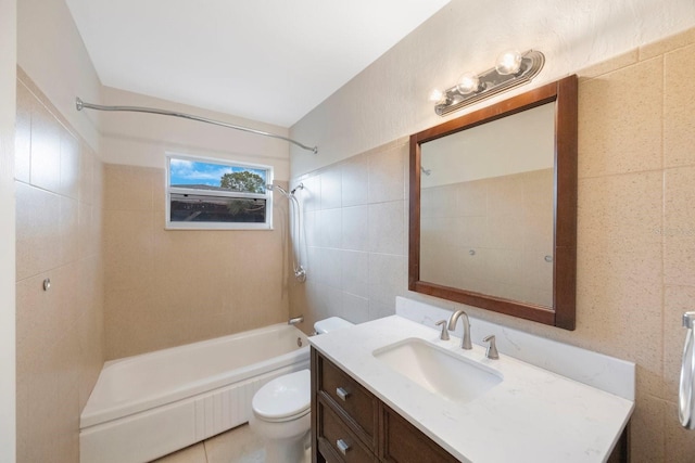 full bathroom with tile walls, vanity, tiled shower / bath combo, and toilet