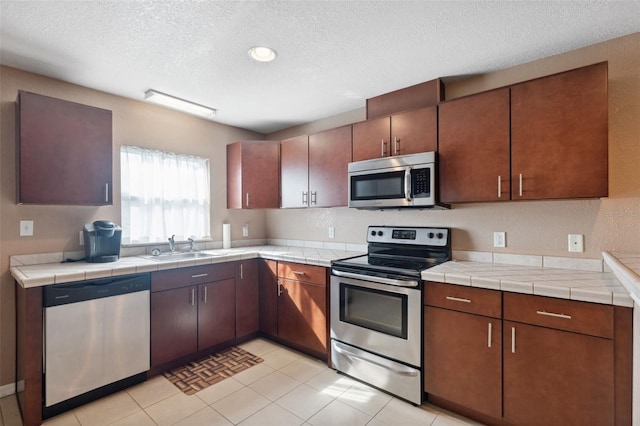 4148 Rudder Way, New Port Richey, FL 34652 - kitchen with appliances with stainless steel finishes, a textured ceiling, light tile patterned floors, and recessed lighting