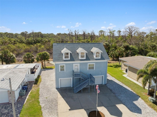 4148 Rudder Way, New Port Richey, FL 34652 - back of house featuring an attached garage, driveway, stucco siding, and stairway