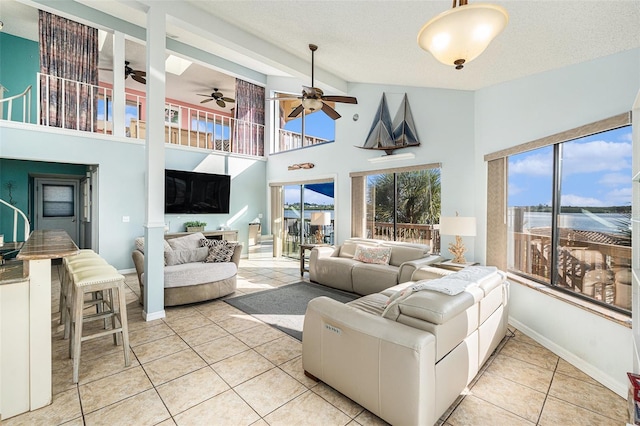 living room with light tile patterned flooring, a towering ceiling, and a textured ceiling