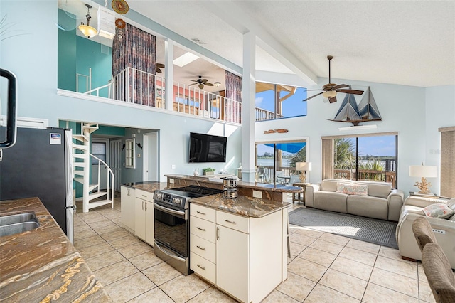 kitchen featuring white cabinets, high vaulted ceiling, light tile patterned floors, and appliances with stainless steel finishes