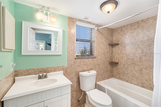 full bathroom featuring vanity, shower / bath combination with curtain, toilet, and tile walls