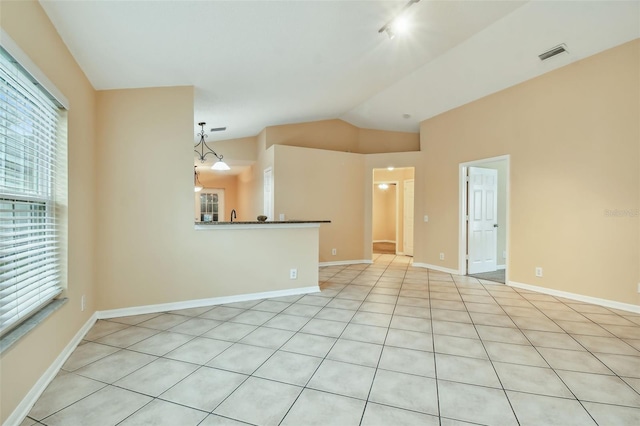 unfurnished living room featuring light tile patterned flooring and lofted ceiling