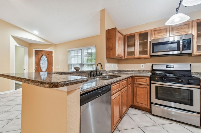 kitchen with kitchen peninsula, stainless steel appliances, sink, light tile patterned floors, and lofted ceiling