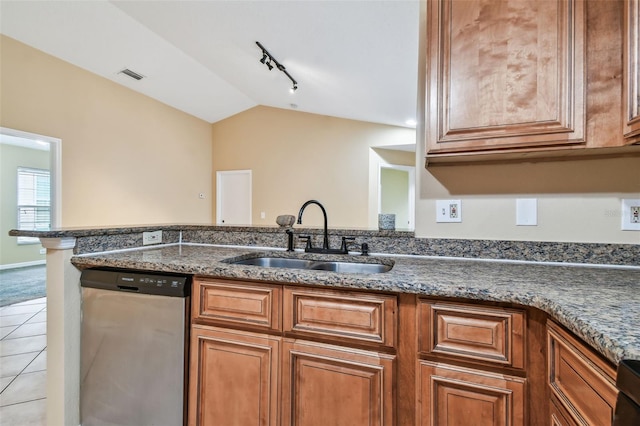 kitchen featuring dishwasher, sink, vaulted ceiling, dark stone countertops, and light tile patterned floors