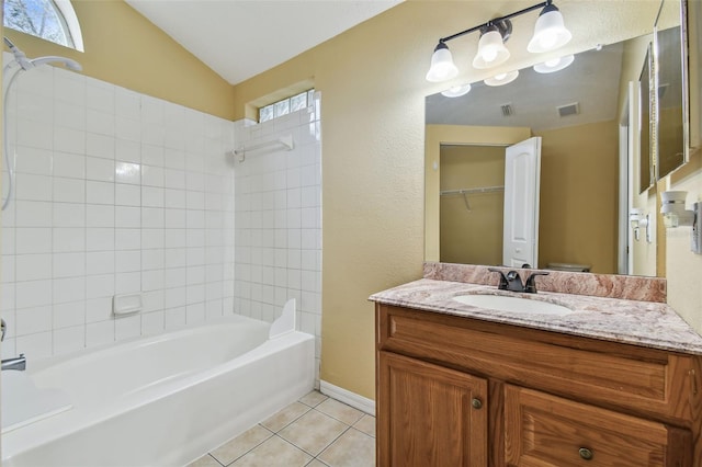 bathroom with tile patterned flooring, vanity, vaulted ceiling, and a healthy amount of sunlight