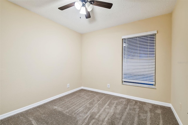 spare room with a textured ceiling, carpet floors, and ceiling fan