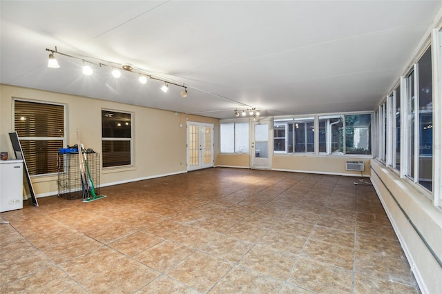 interior space with rail lighting, plenty of natural light, and a wall mounted AC