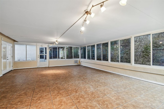 unfurnished sunroom featuring track lighting and a wall mounted AC