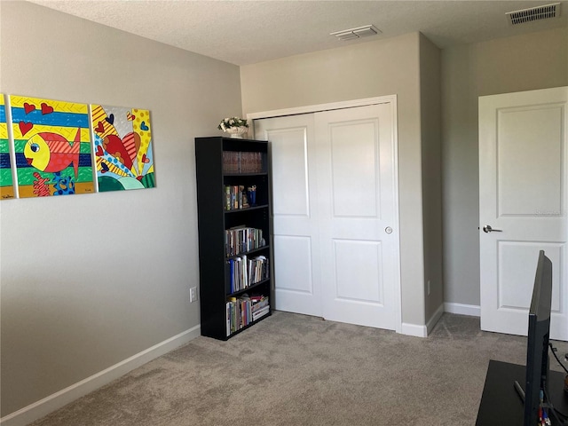 interior space featuring carpet floors and a textured ceiling