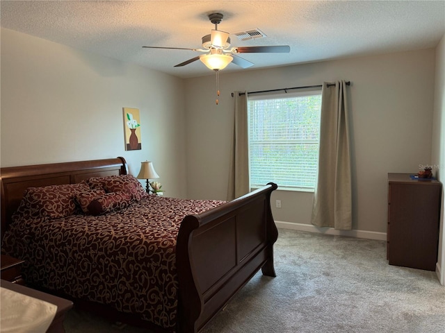 carpeted bedroom with a textured ceiling and ceiling fan