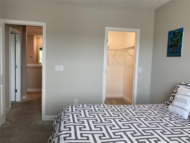 carpeted bedroom with a walk in closet and a closet