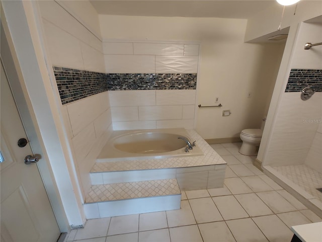 bathroom featuring tile patterned flooring, toilet, and tiled tub