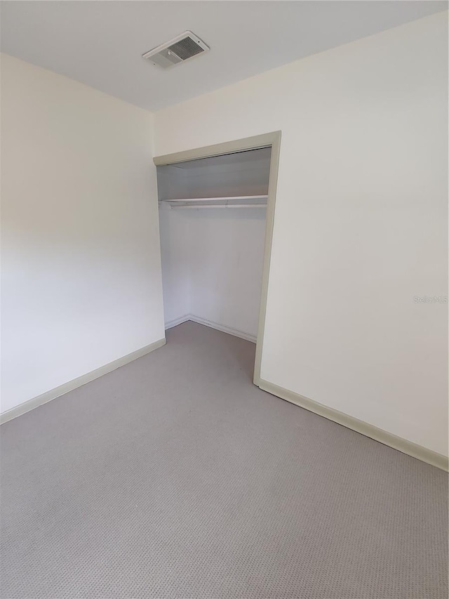 unfurnished bedroom with carpet and a closet