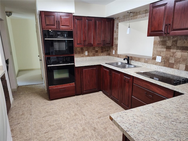 kitchen with tasteful backsplash, pendant lighting, sink, and black appliances