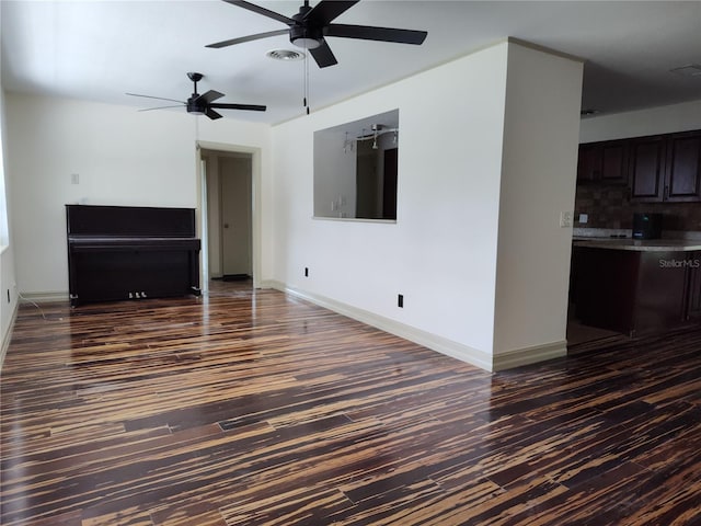 unfurnished living room featuring ceiling fan and dark wood-type flooring